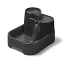 Eine frontale Schrägansicht des grauen Haustierbrunnes von Cat Mate, der für Katzen und kleine Hunde geeignet ist und Wasser zeigt, das zu allen drei Ebenen hinunterfließt, vor weißem Hintergrund.