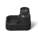 Eine seitlich angewinkelte Ansicht des leeren grauen Haustier-Wasserbrunnens mit drei verschiedenen Ebenen, aus denen Haustiere wählen können zu trinken, vor weißem Hintergrund.