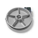 Eine Draufsicht auf einen automatischen Haustierfutterspender mit entferntem Deckel, der sechs leere graue Futterkammern zeigt, die kreisförmig um einen zentralen Rotationsmechanismus angeordnet sind, mit einem digitalen Bedienfeld mit LCD-Display und Tasten in der oberen rechten Ecke, alles vor weißem Hintergrund.