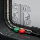 Eine Nahaufnahme der linken Ecke der grauen Katzenklappe zeigt zwei der manuellen Schlösser, die rot und grün sind, sowie die wetterfeste Bürste