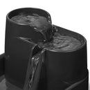 Eine Nahaufnahme der oberen beiden Ebenen des dreistufigen Brunnens in Grau, mit Wasser, das an ihnen hinunterfließt, vor weißem Hintergrund.