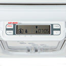 Nahaufnahme des digitalen Bedienfelds Cat Mate Elite an einer weißen Mikrochip-Katzenklappe. Das LCD-Display zeigt Symbole eines Hauses und einer Katzenfigur mit Richtungspfeilen sowie die Zeitanzeige '07:05'. Das Bedienfeld verfügt über Tasten mit der Beschriftung 'PROG' (Programm), '4 WAY', 'TIMER' und eine '+'-Taste, mit nummerierten Tasten 1, 2 und 3 unterhalb des Displays. Pfotenabdruck-Verzierungen sind auf dem durchsichtigen Plastikklappen-Teil der Katzentür sichtbar.